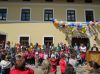 Quelle: KiGa Lengdorf - erste Bürgermeisterin Michèle Forstmaier (rechts am Rednerpult) mit der fröhlichen Kinderschar vor dem geschmückten Kindergarten